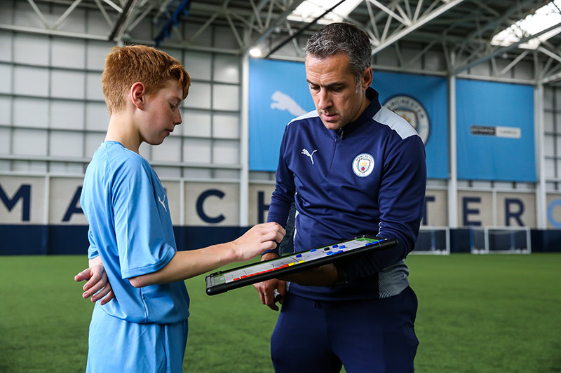 A male coach at Manchester City Football School. 